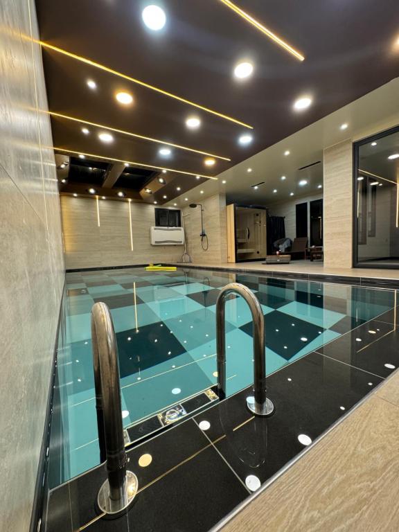 a swimming pool with two faucets in a building at Villa Jonchère in Chanteloup-en-Brie