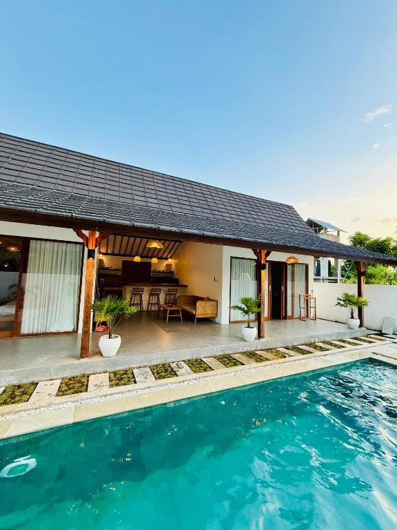 a villa with a swimming pool and a house at VILLA Santay byAdiba in Gili Islands
