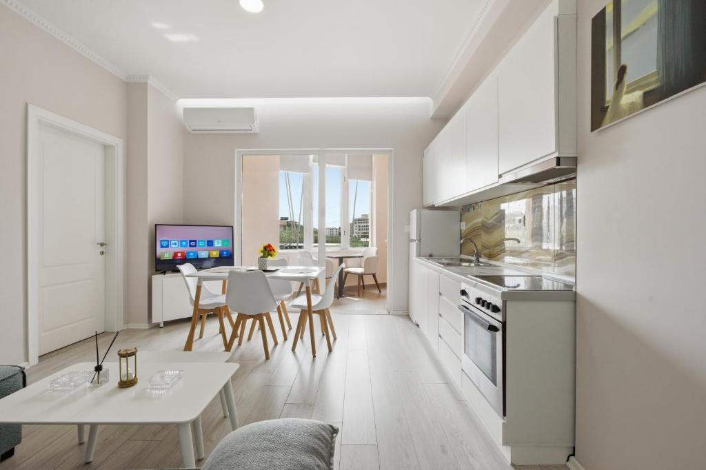 a kitchen and living room with a table and chairs at The Cliff Suites in Golem