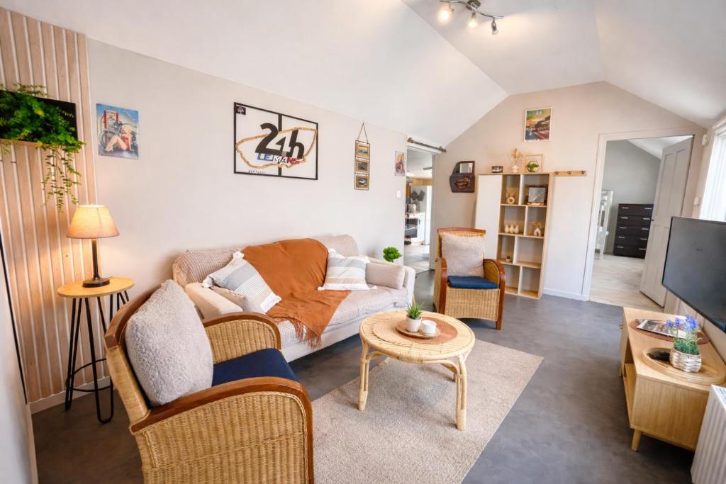 a living room with a couch and a tv at Le Refuge du Mans in Le Mans