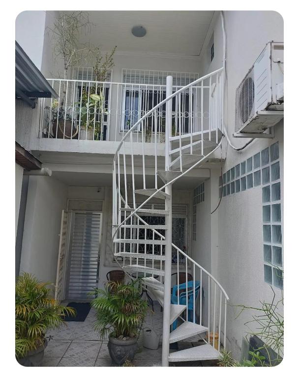 a white spiral staircase in a building with plants at Simplicidade e localização privilegiada no coração de Adrianópolis em Manaus in Manaus