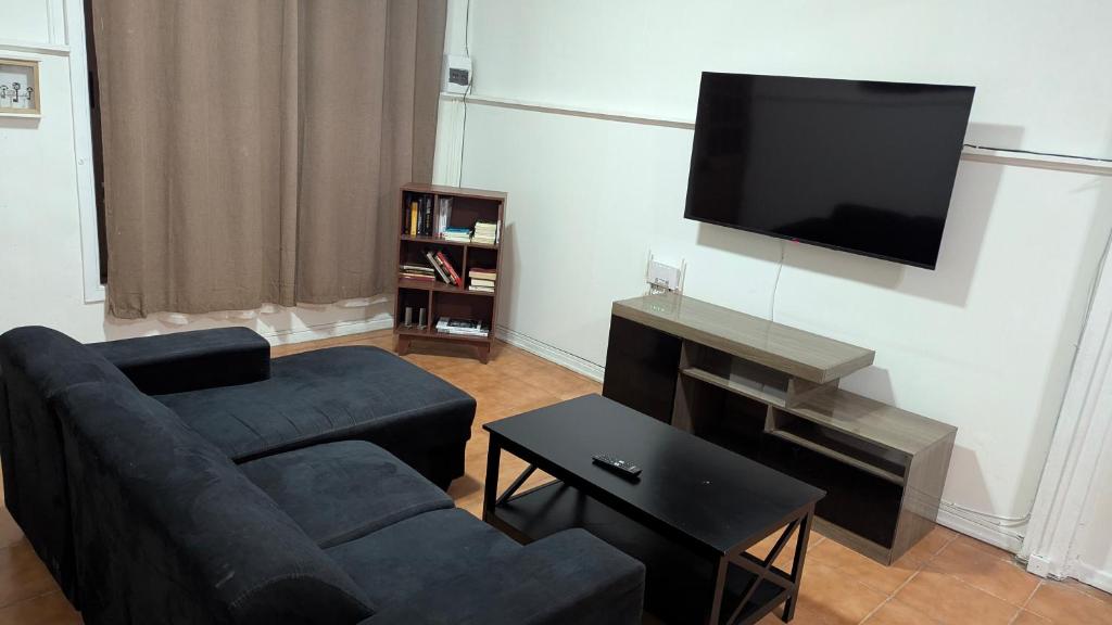 a living room with a couch and a flat screen tv at Residencia cercana ENGIE in Tocopilla