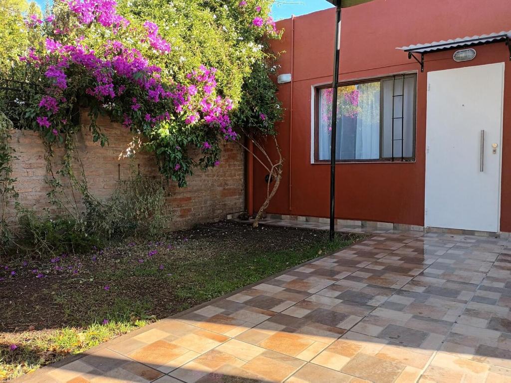 a house with purple flowers on the side of it at Departamento CRIMAR in Viedma