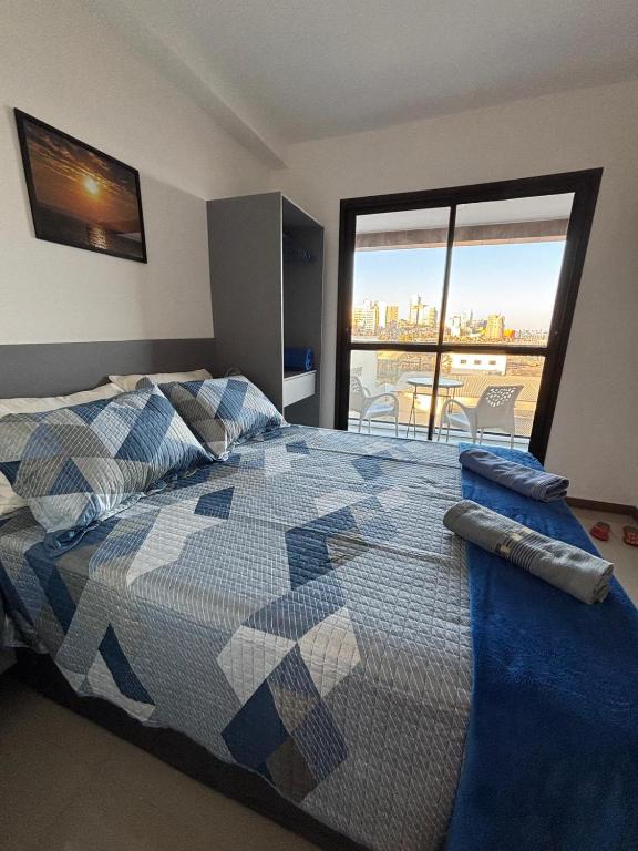 a bedroom with a bed with a view of the city at Studio nascente na Pituba in Salvador