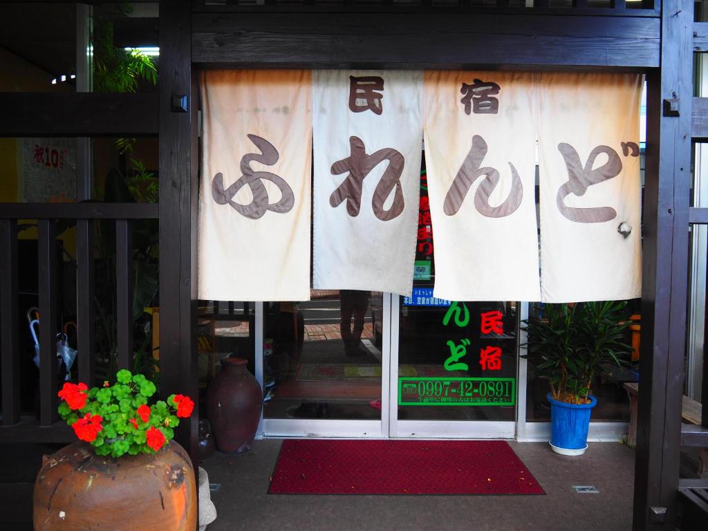 屋久島的住宿－朋友不眠旅館，商店前部有窗户,上面写着