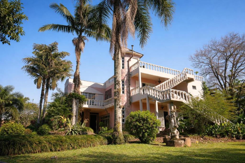 an exterior view of a house with palm trees at Primeiro Hostel in Praia Grande
