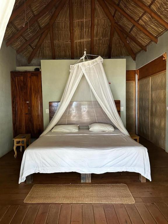 a bedroom with a bed with a mosquito net at Bungalos Blanca in Temalhuacán