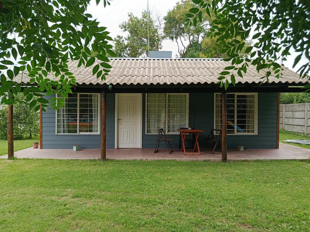 a blue house with a porch and a table at El Descanso in Las Flores