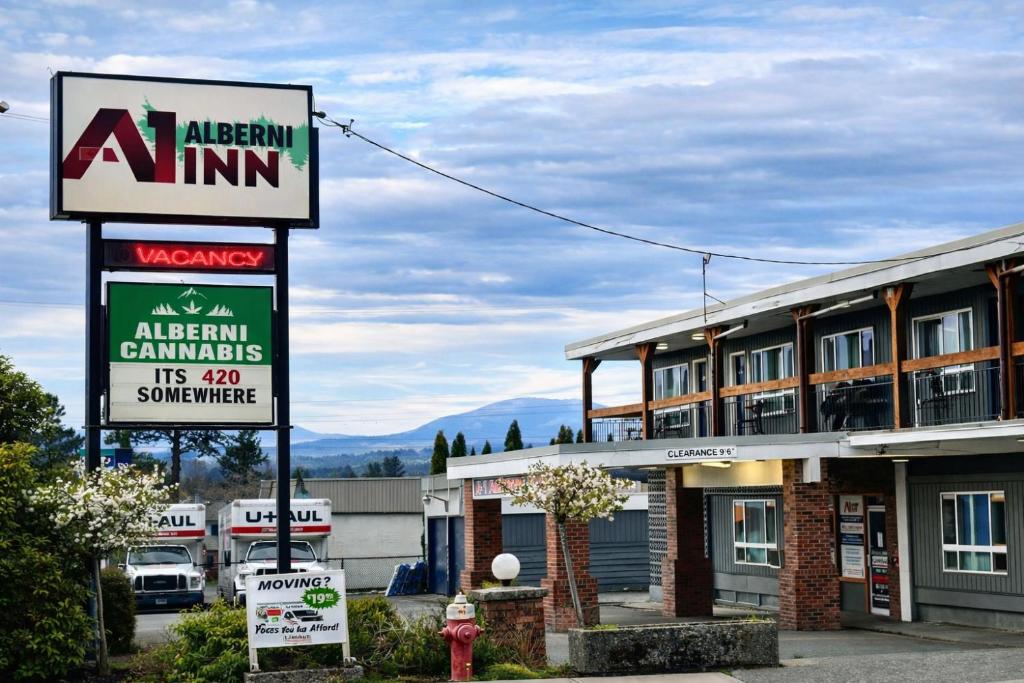 a sign for an alpine inn with a building at Alberni Inn in Port Alberni