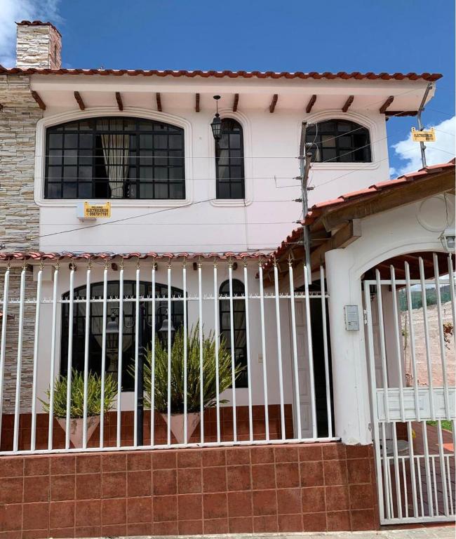 a white house with a gate in front of it at Rincón de Paz y Tranquilidad in Ambato