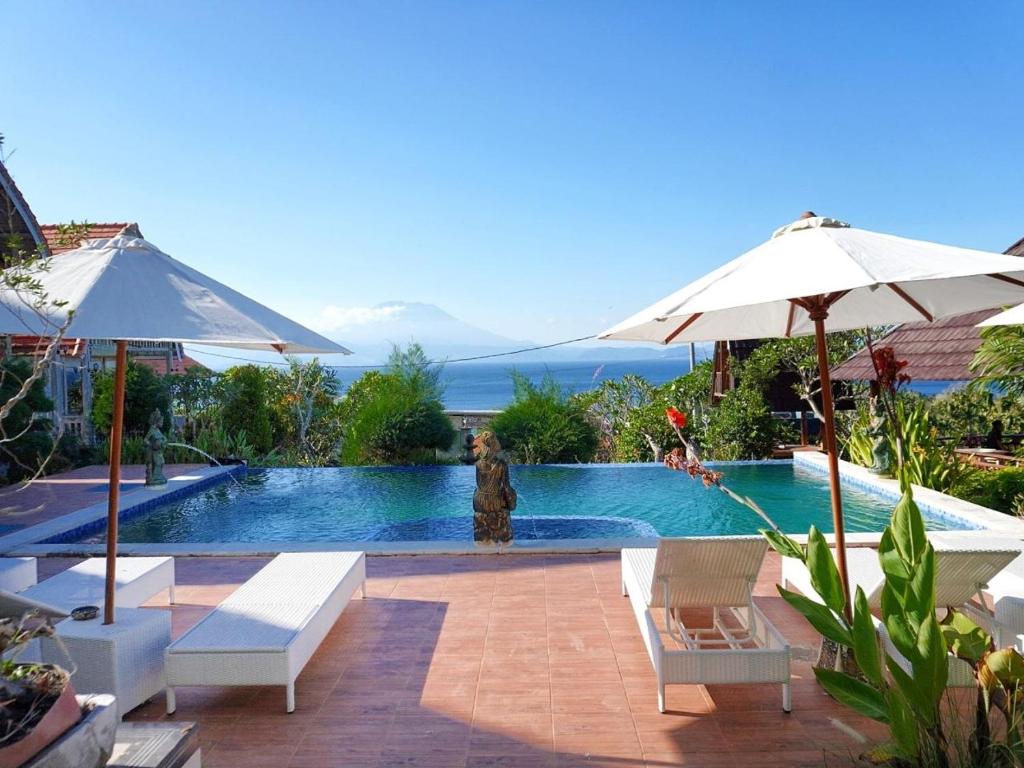 a swimming pool with a statue in the middle of it at Darya Sea View by ABM in Nusa Penida