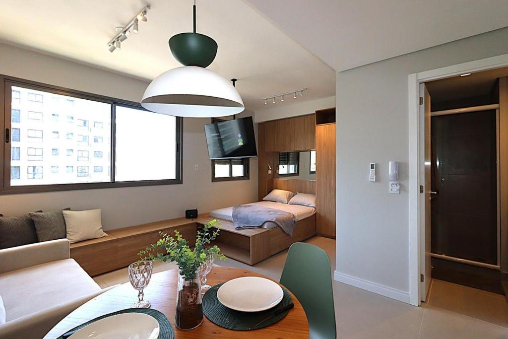 a living room with a couch and a table in a room at MOOD Modern Studio, Central Parque in Porto Alegre