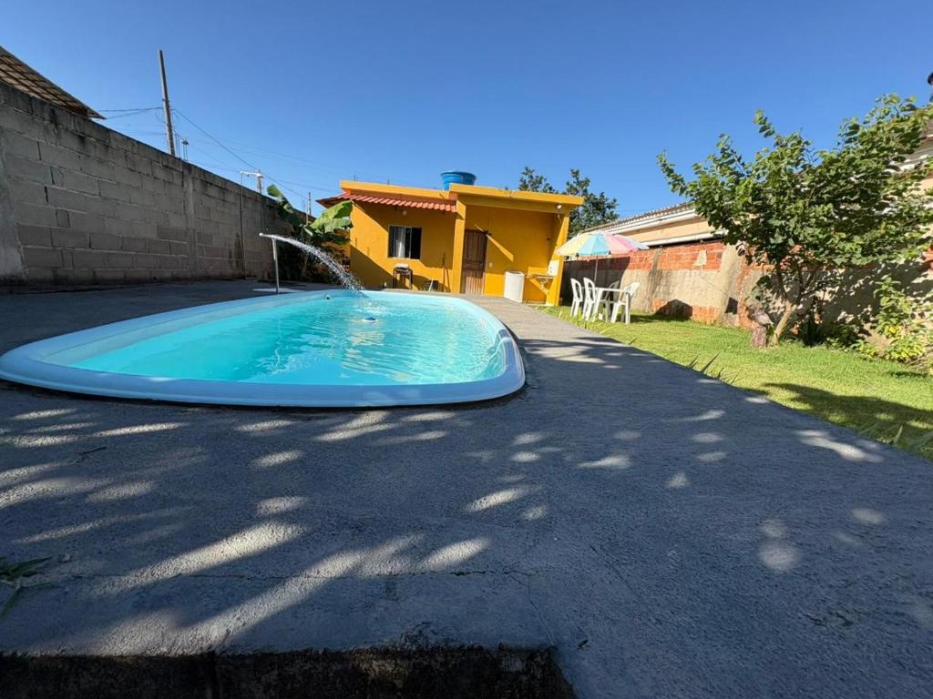 a blue swimming pool in the middle of a driveway at CasadaKassia in Itapemirim