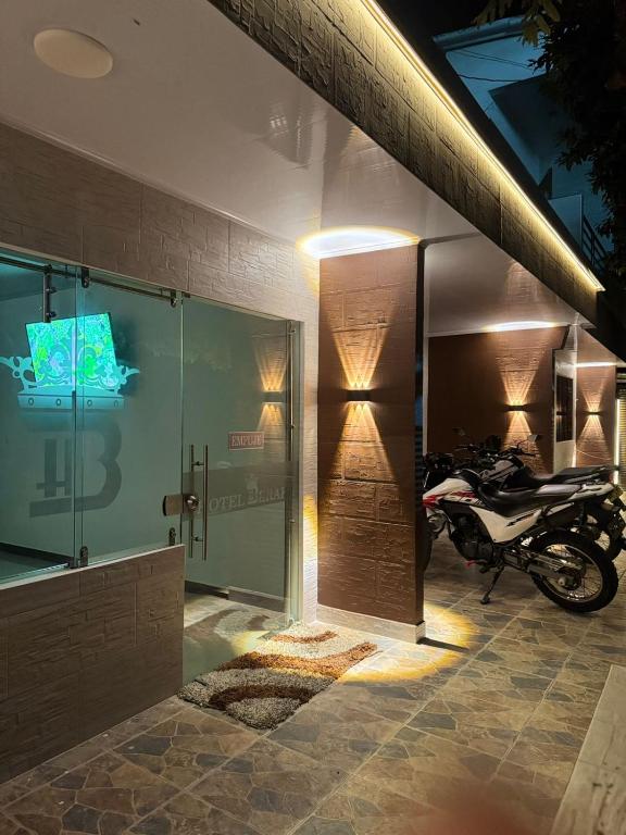 a motorcycle parked in a room with a glass door at Hotel Beraka in Fortul
