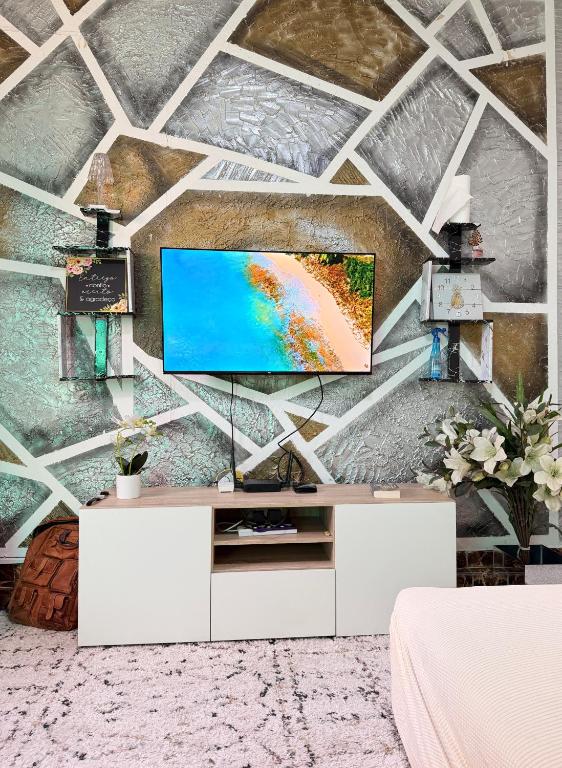 a living room with a tv on a wall at Maculusso Hidden Gem Central & Comfortable Apartment in Luanda