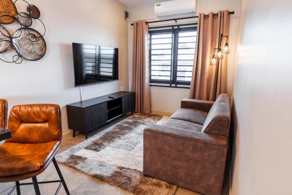 a living room with a couch and a television at Lobby Apartments in Paramaribo