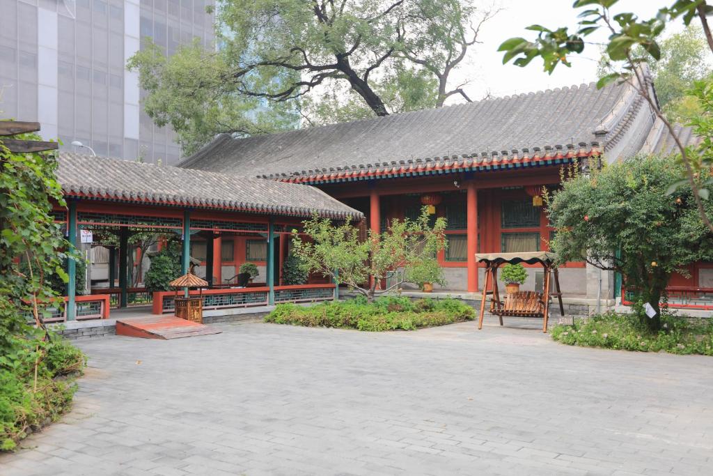 um edifício com um telhado vermelho num pátio em Beijing Jingyuan Courtyard Hotel em Pequim