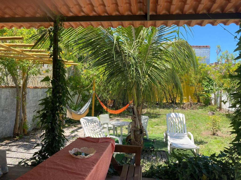 a patio with a table and chairs and a hammock at Recanto Mariel - 800m praia 2 quartos churrasqueira chuveirão rede Itaipuaçu in Maricá