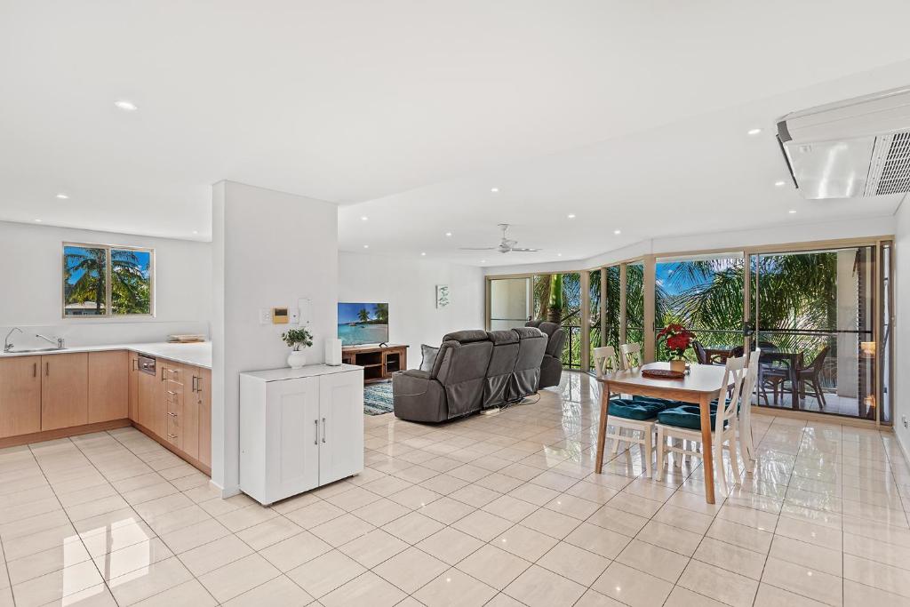 a kitchen and living room with a table and chairs at The Crabpot in Airlie Beach