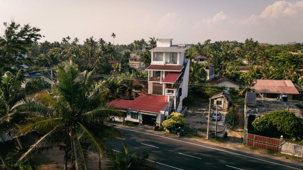 a house on a street with a palm tree at Rockvin BnB in Midigama East