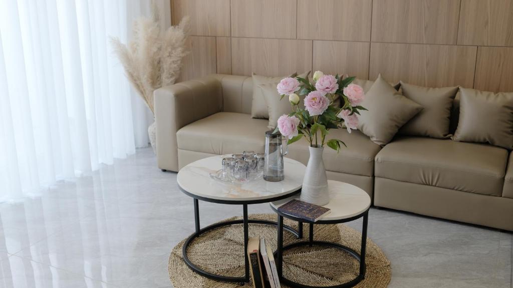 a living room with a couch and a table with flowers at Achi Ocean Villa in Cửa Lô