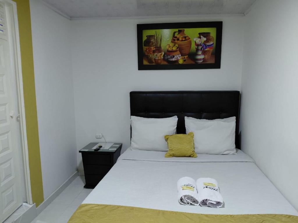 a bedroom with a bed with two slippers on it at Casa hotel Comunicar Nini in Bogotá