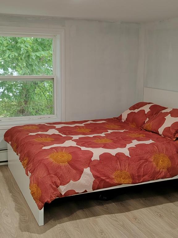 a bedroom with a bed with a red floral comforter at Bright Spacious Room-3B in Halifax