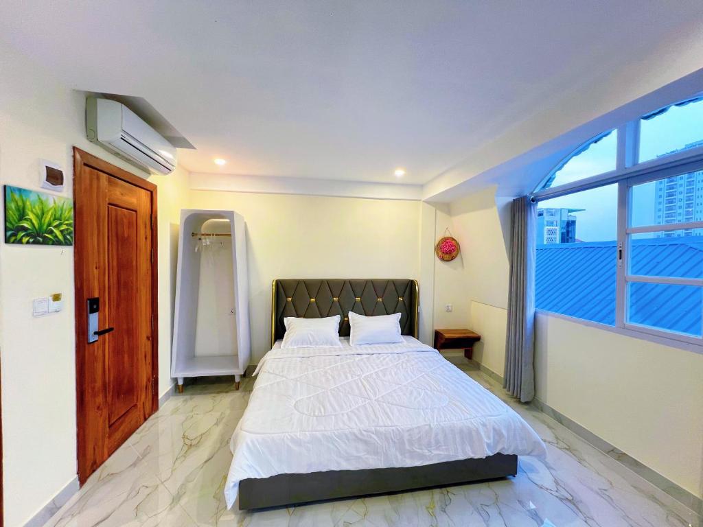 a bedroom with a bed and a large window at A Z Hotel Phnom Penh in Phnom Penh