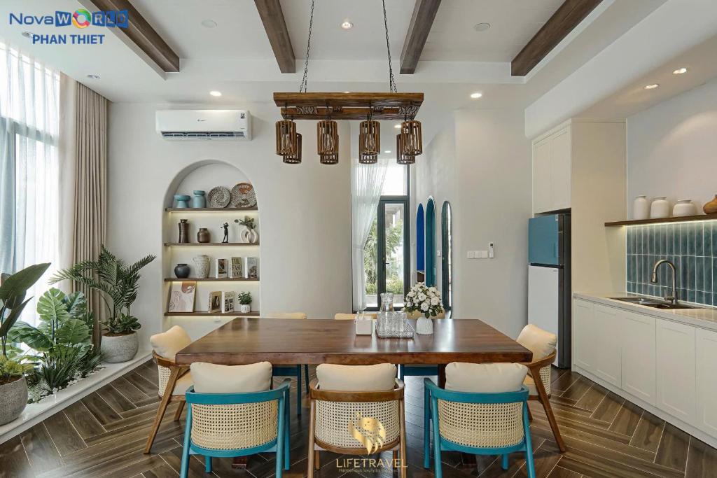 a dining room with a wooden table and chairs at Santorini Homestay Phan Thiet in Tiến Thành