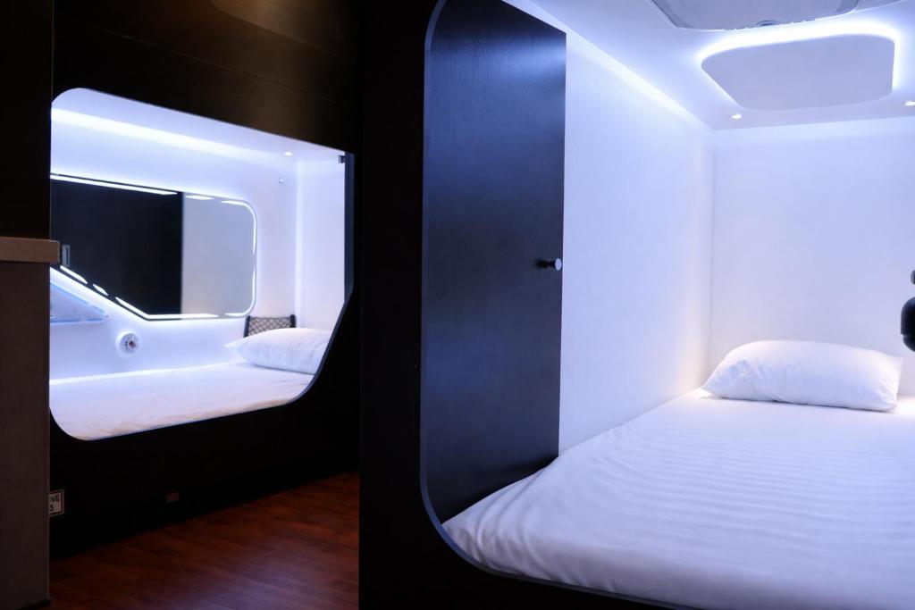 a small room with a bed and a mirror at Auckland Boutique Capsule in Auckland