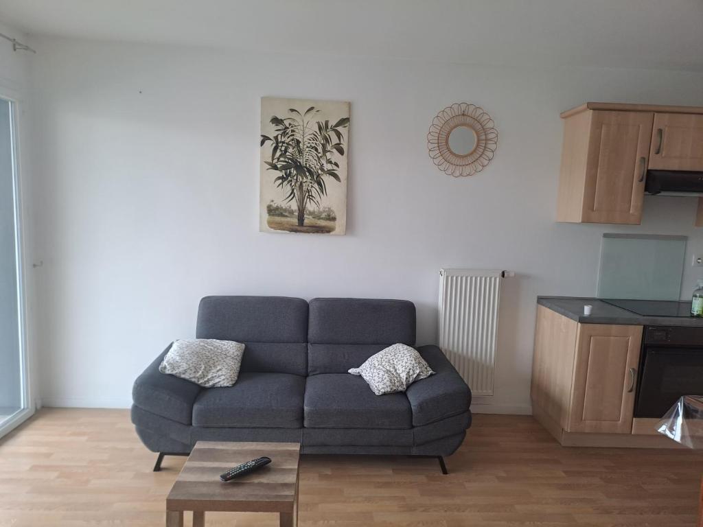 a living room with a couch and a table at Gite des Capucines in Bourbourg