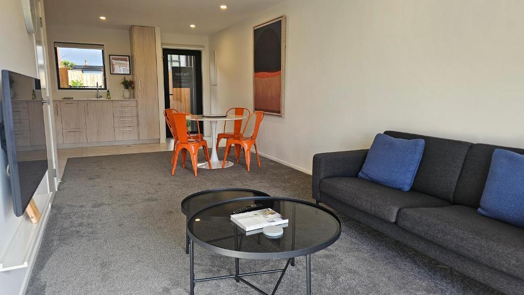a living room with a couch and a table at 20 Te Kanawa Haven in Auckland