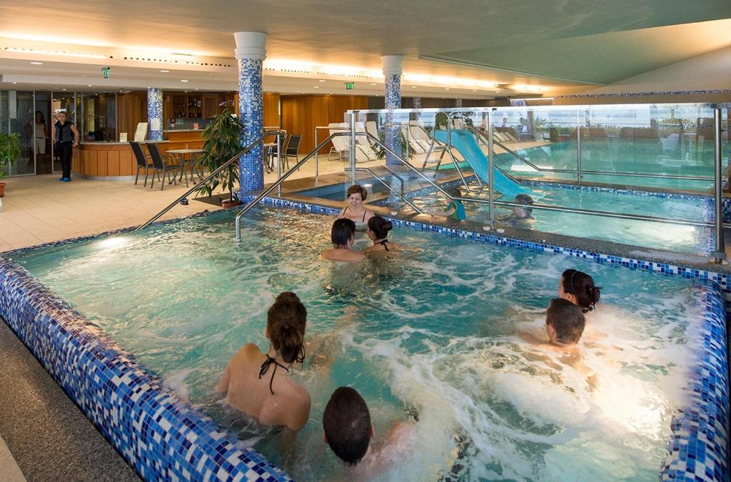 a group of people in a swimming pool at Zenit Wellness Hotel Balaton in Vonyarcvashegy