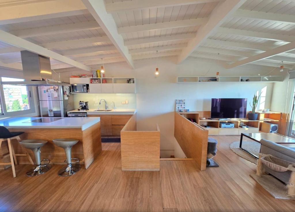 a large kitchen with a counter and a table at Duplex Premium Ciudad Jardín in El Palomar