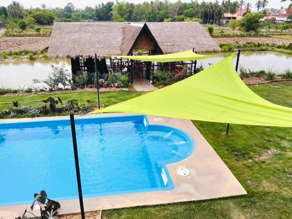 a tent and a swimming pool in front of a house at Isaan Country Retreat in Mukdahan