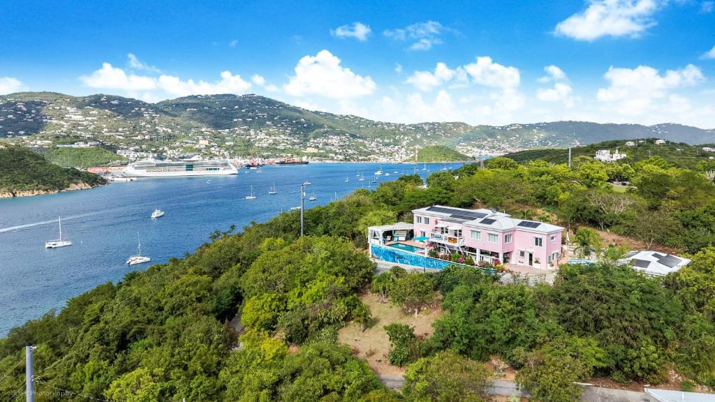 a house on a hill next to a body of water at Villa Serena Water Island in Water Island