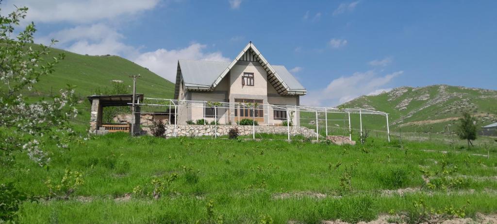 a house on top of a grassy hill at Le Fortin in Samarkand