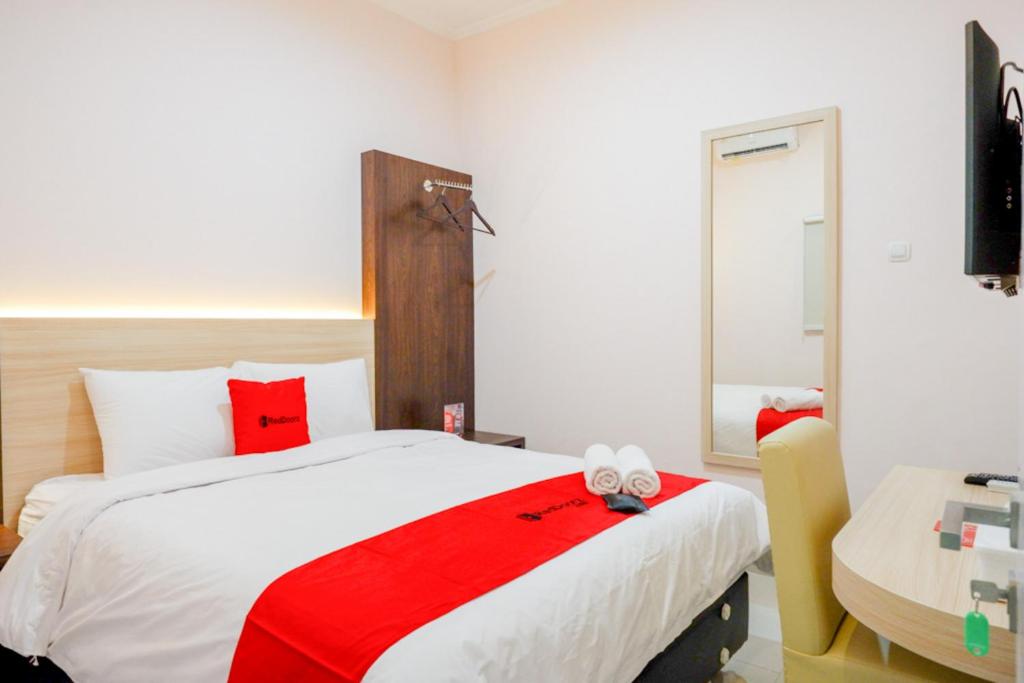 a bedroom with a large bed with red pillows at RedDoorz near Gejayan 3 in Yogyakarta