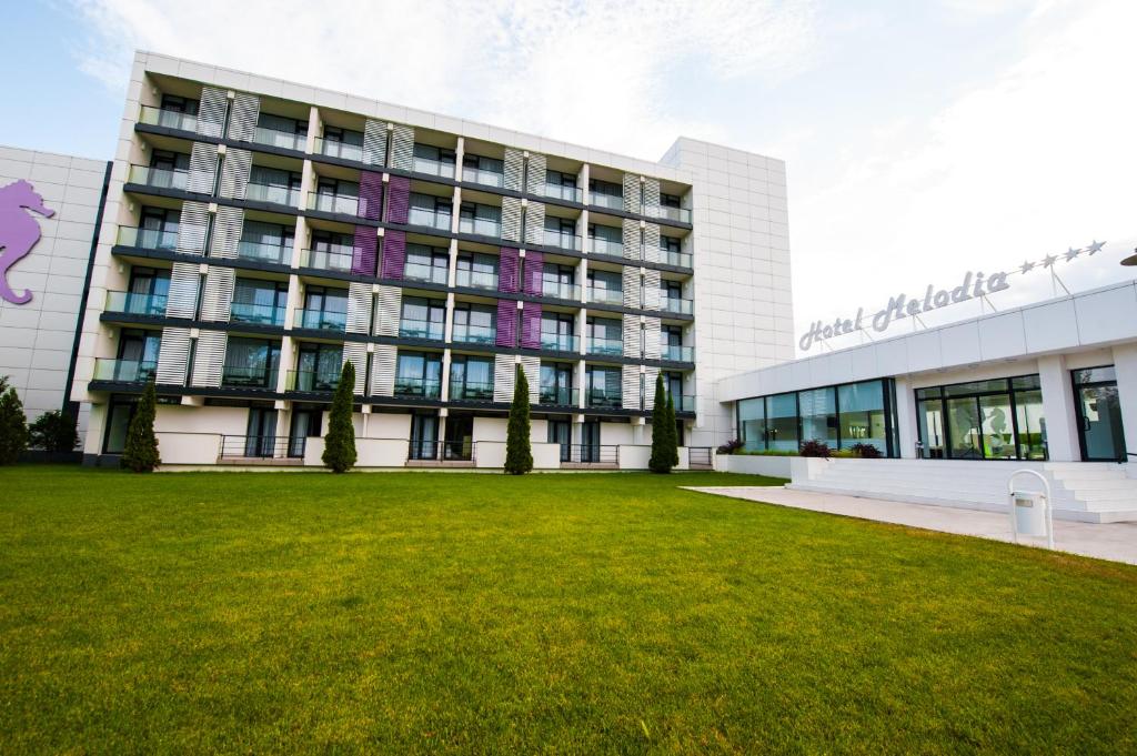 a building with a lawn in front of it at Hotel Melodia in Venus