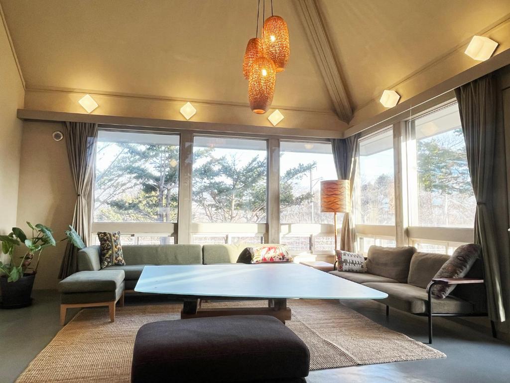 a living room with a couch and a table at ROHAUS Entire Home with private Hot Spring in Shiraoi