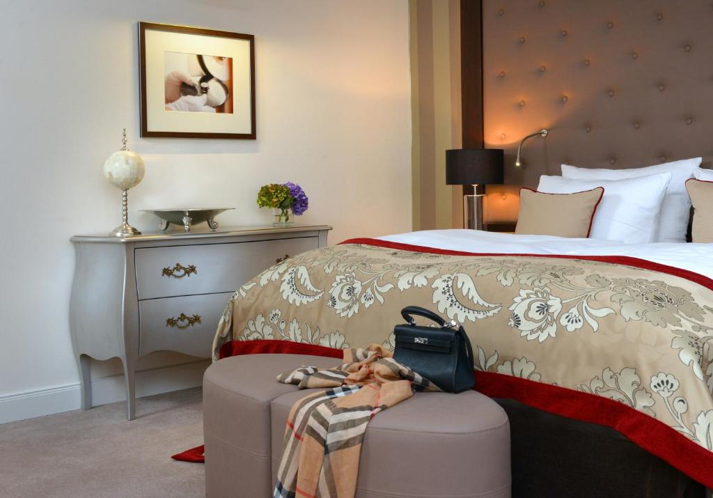 a hotel room with a bed with a suitcase at Romantik Hotel Burgkeller Residenz Kerstinghaus in Meißen