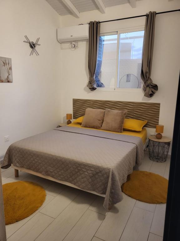 a bedroom with a bed with yellow pillows and a window at Paradise House in Saint-François