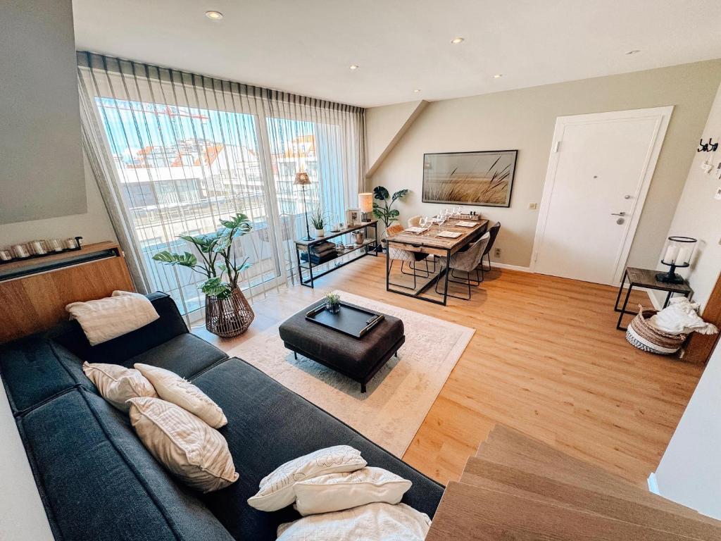 a living room with a couch and a table at la MERéMOI - Duplex Knokke with balcony and free parking in Knokke-Heist