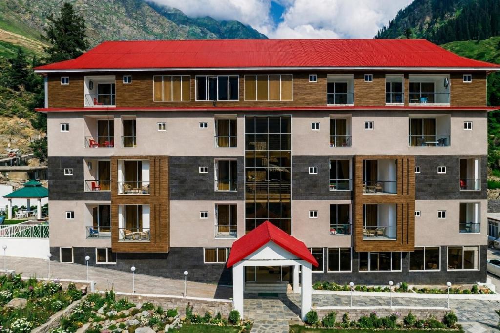 an apartment building with a red roof at Belmont Naran in Naran