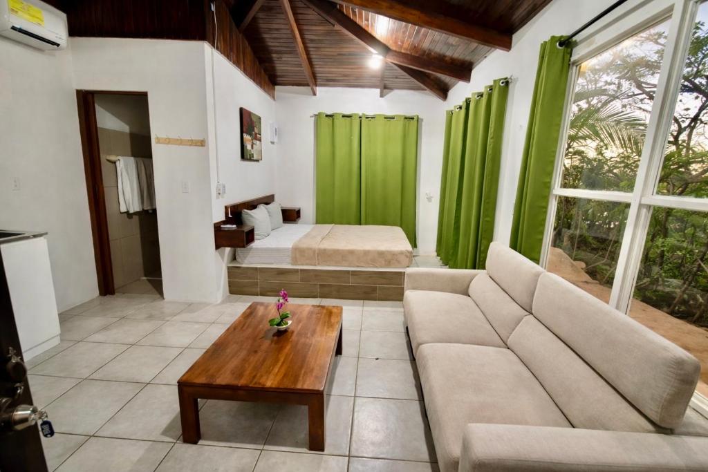 a living room with a couch and a bed at Green Point Nosara in Nosara