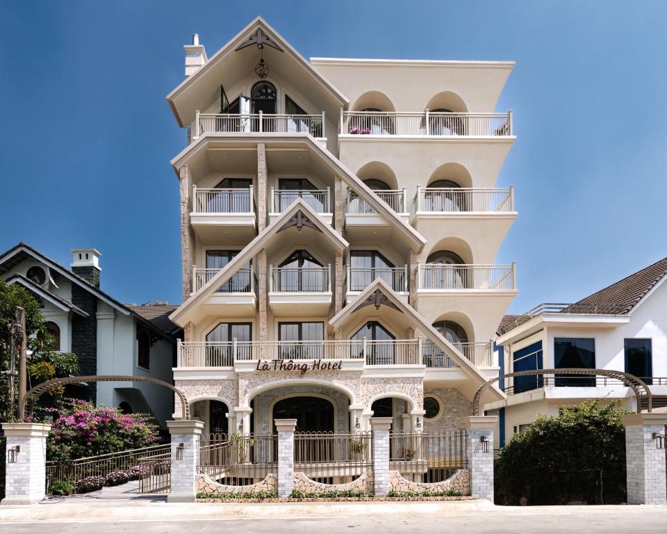 a large white building with a balcony at Là Thông Boutique Đà Lạt in Da Lat