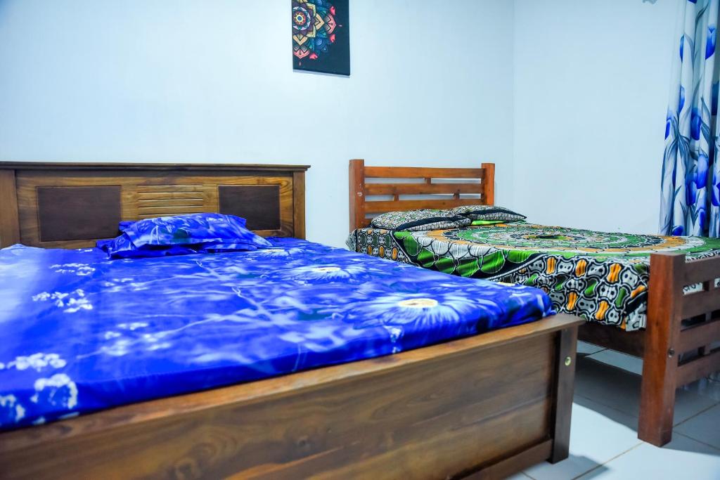 a bedroom with two beds with blue sheets at Misty Peaks Villa in Haldummulla