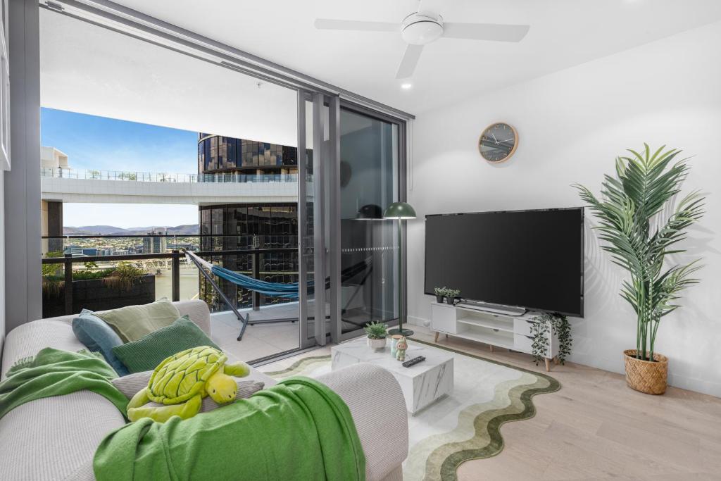 a living room with a flat screen tv and a couch at Matcha Madness Zen Escape - Riverfront in Brisbane