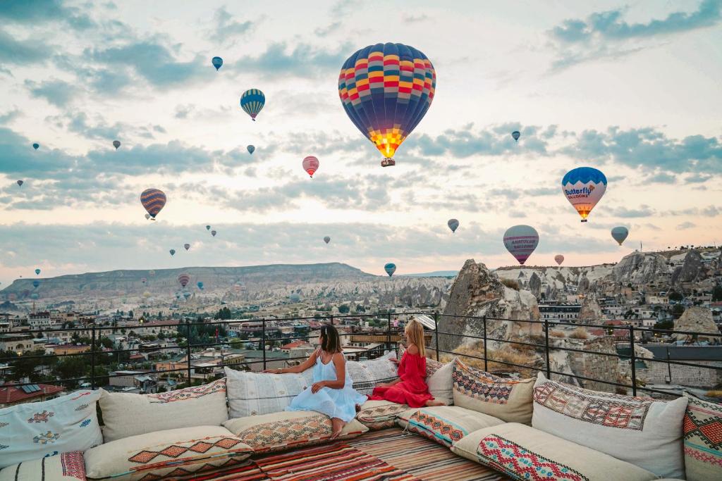 two women sitting on a couch watching hot air balloons at Luvi Cave Hotel in Göreme