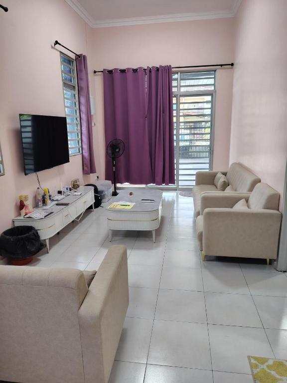 a living room with two couches and a tv at Jaya's Homestay in Simpang Ampat